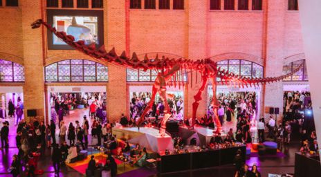Exhibitors at ROM After Dark around a dinosaur skeleton