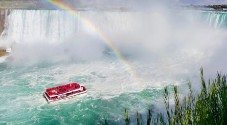 Hornblower Boat Cruise on the water, near Niagara Falls with a rainbow shining above it