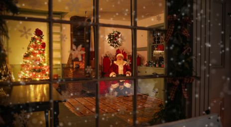A cozy Christmas scene viewed through a window shows Santa Claus sitting by a glowing Christmas tree and festive decorations inside a warmly lit room.