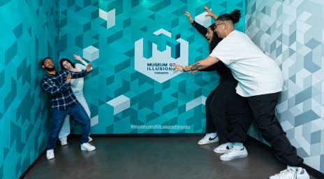 Four people posing in an optical illusion room at the Museum of Illusions Toronto.