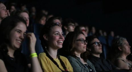 Audience members smiling and watching a film during the Vaughan International Film Festival.